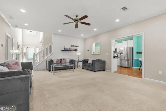 a living room with furniture and kitchen view
