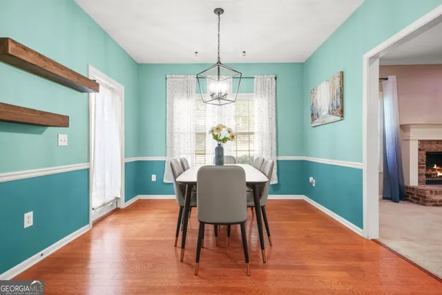 a dining room with furniture a chandelier and wooden floor