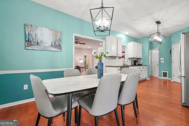 a view of a dining room with furniture a chandelier and wooden floor