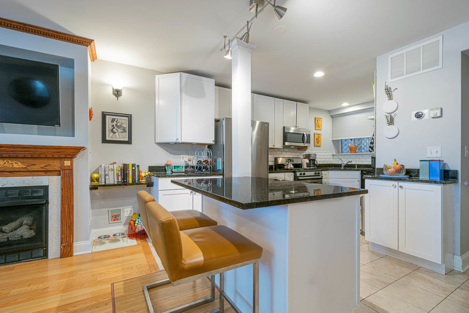5874 North Ridge Avenue, Unit G Chicago, IL 60660 - Photo 8 of 14 a kitchen with stainless steel appliances granite countertop a refrigerator a stove top oven a sink dishwasher and fireplace with wooden floor