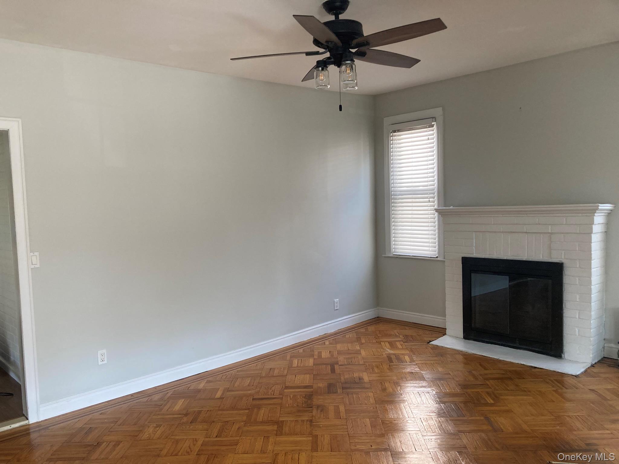 513 Marcellus Road, Unit 1 Williston Park, NY 11596 - Photo 3 of 11 a view of an empty room with window and fireplace