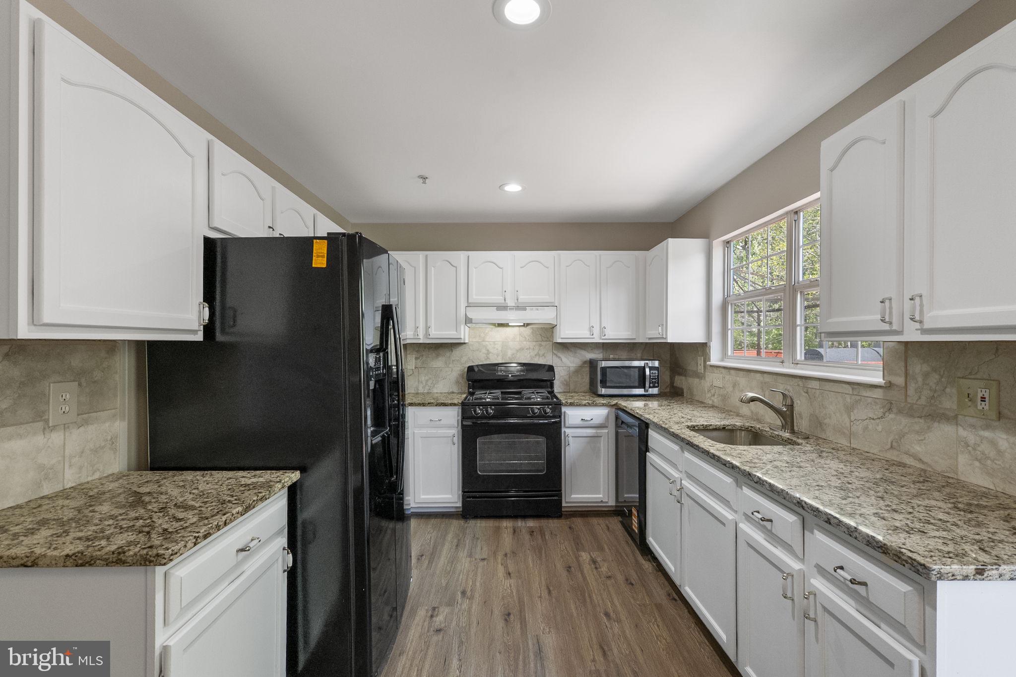3514 Corn Stream Road Randallstown, MD 21133 - Photo 18 of 44 a kitchen with granite countertop stainless steel appliances a sink stove and refrigerator