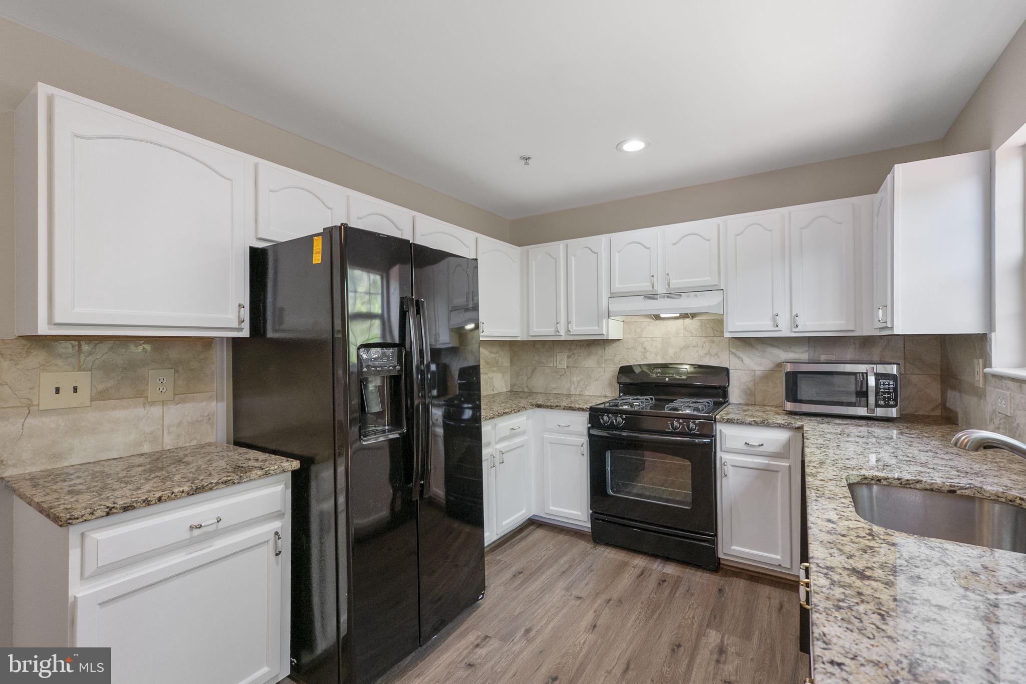 3514 Corn Stream Road Randallstown, MD 21133 - Photo 19 of 44 a kitchen with a sink stove and refrigerator