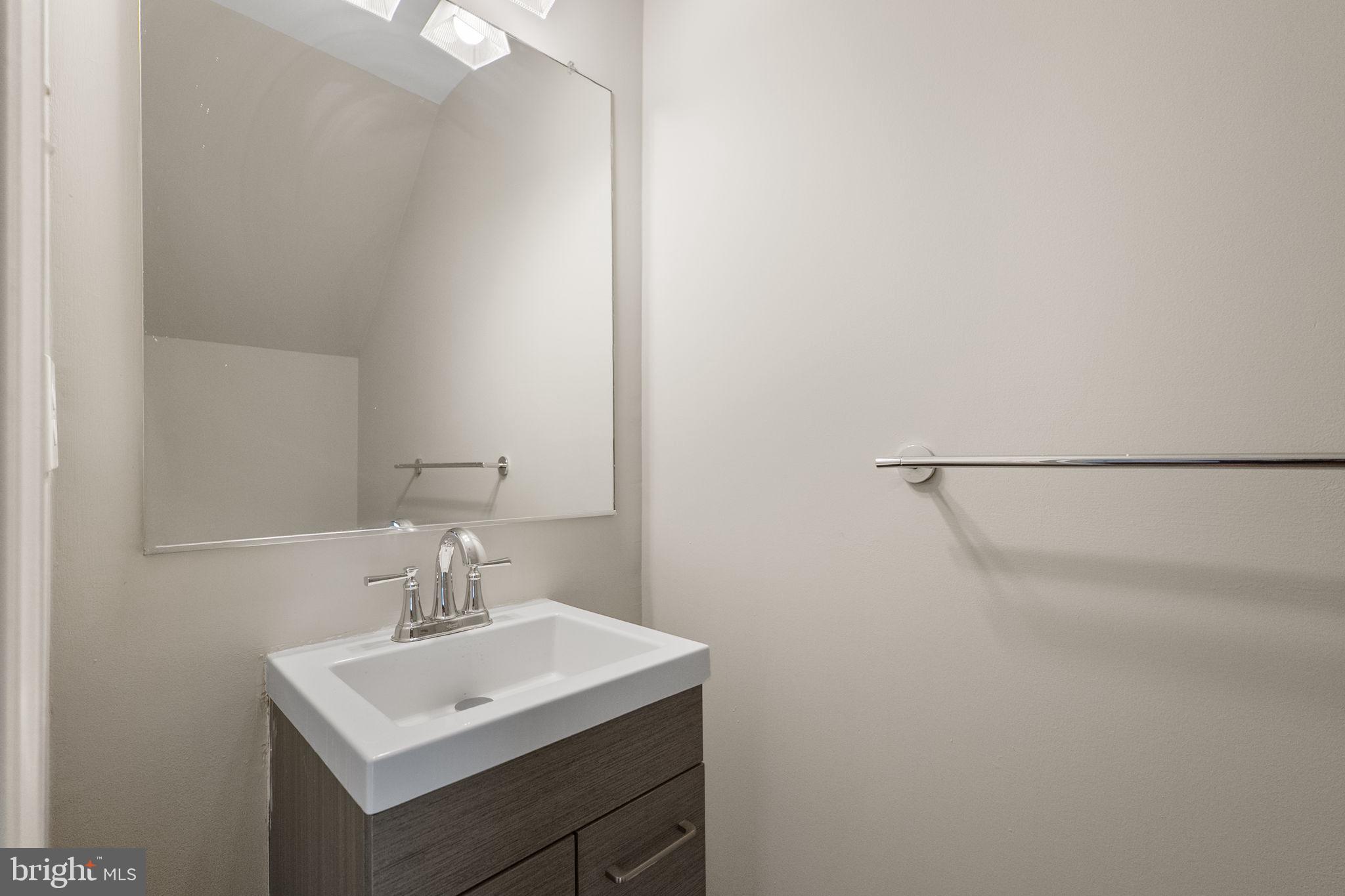 3514 Corn Stream Road Randallstown, MD 21133 - Photo 21 of 44 a bathroom with a sink a mirror and a vanity