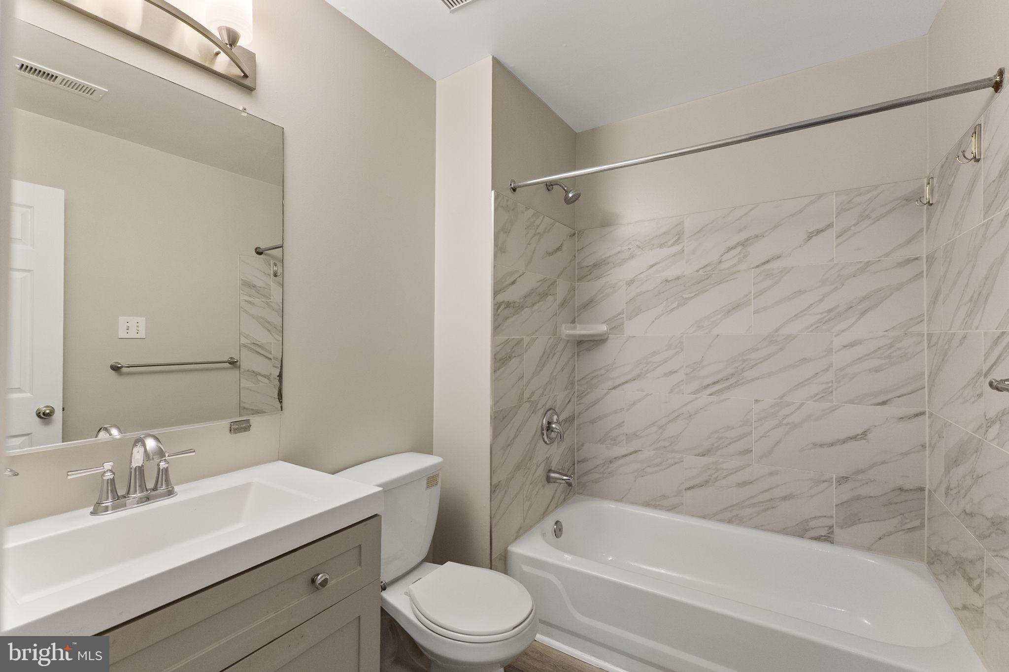 3514 Corn Stream Road Randallstown, MD 21133 - Photo 22 of 44 a bathroom with a bathtub shower sink vanity mirror and toilet