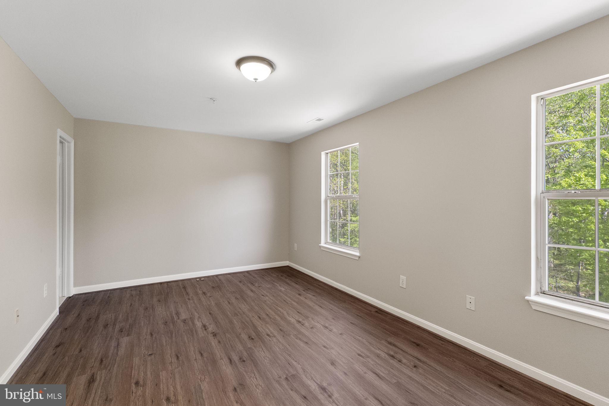 3514 Corn Stream Road Randallstown, MD 21133 - Photo 23 of 44 an empty room with wooden floor and windows