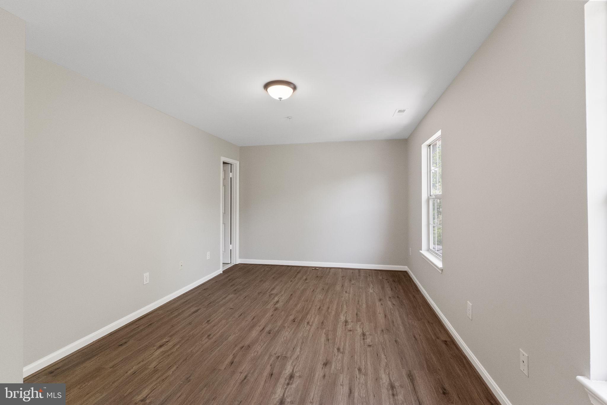 3514 Corn Stream Road Randallstown, MD 21133 - Photo 24 of 44 an empty room with wooden floor and windows