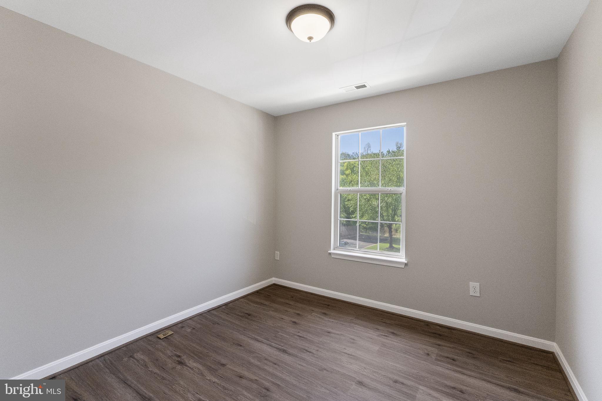 3514 Corn Stream Road Randallstown, MD 21133 - Photo 27 of 44 an empty room with wooden floor and windows