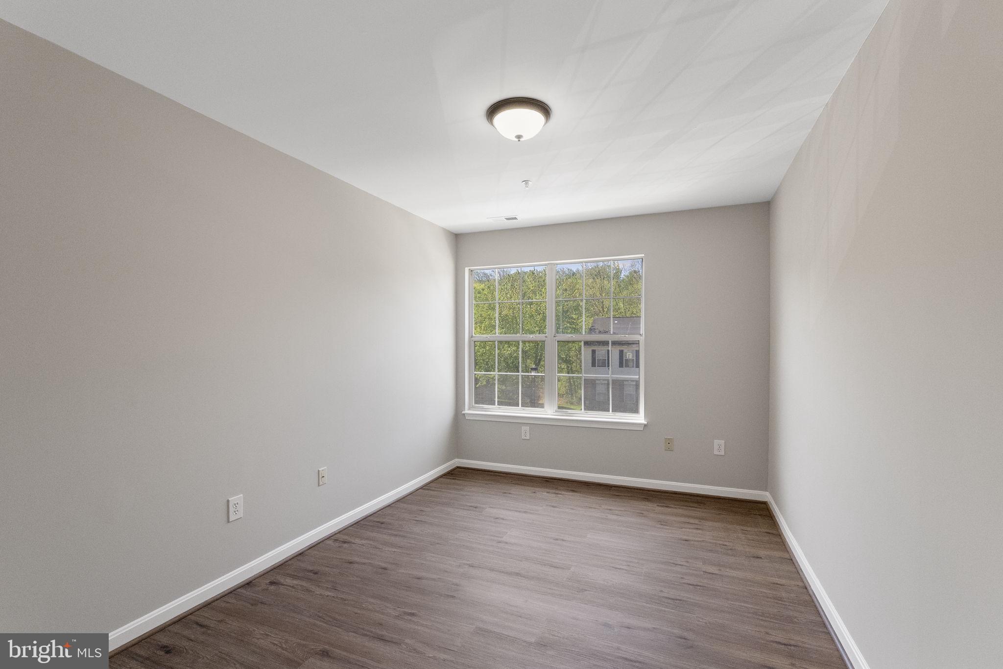 3514 Corn Stream Road Randallstown, MD 21133 - Photo 28 of 44 an empty room with wooden floor and windows