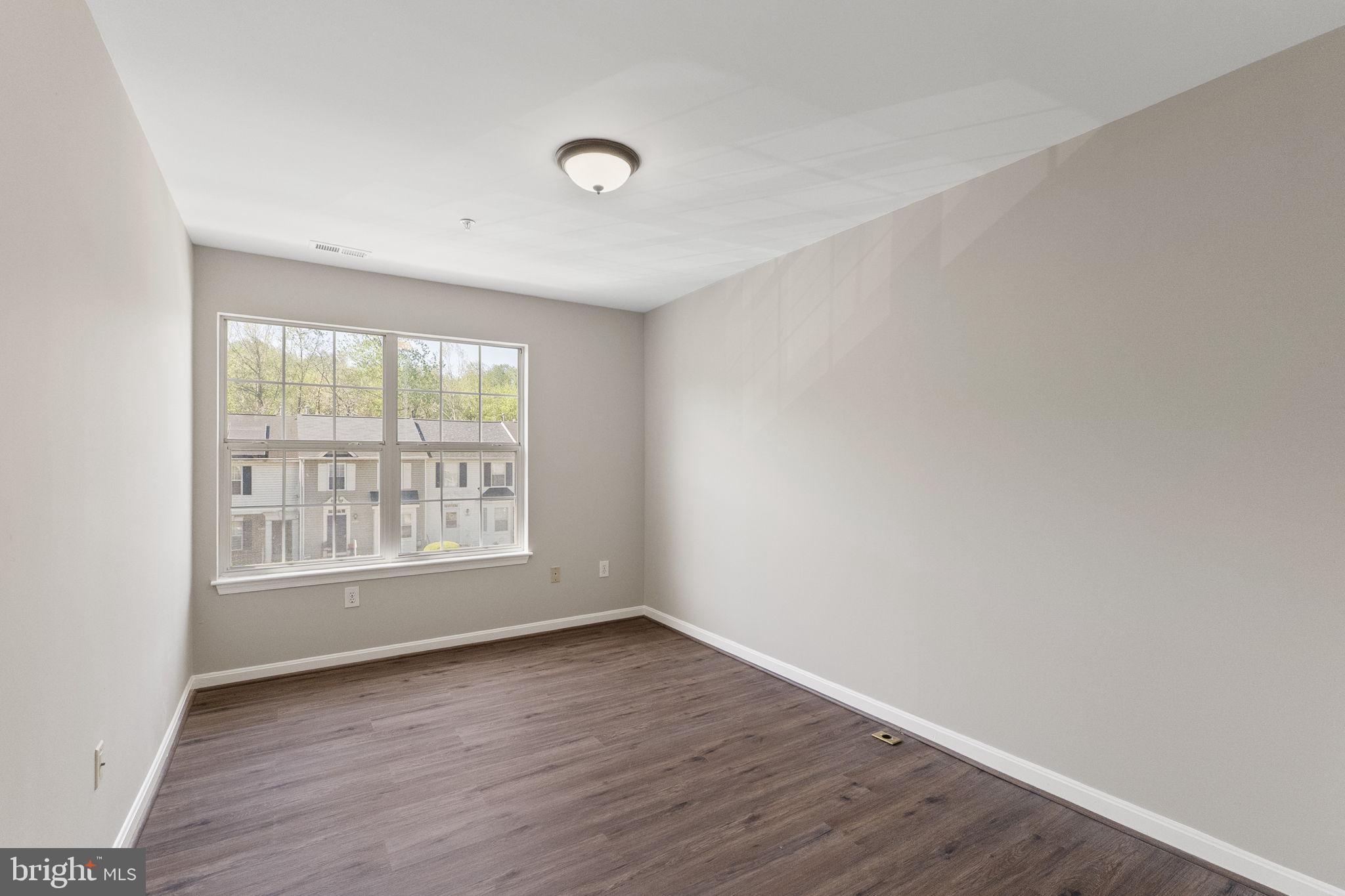 3514 Corn Stream Road Randallstown, MD 21133 - Photo 29 of 44 an empty room with wooden floor and windows