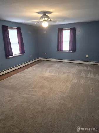 en empty room with windows and ceiling fan