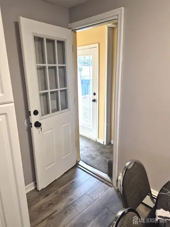 a view of an entryway with wooden floor and door