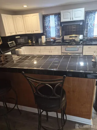 a kitchen with a sink a stove cabinets and a dining table