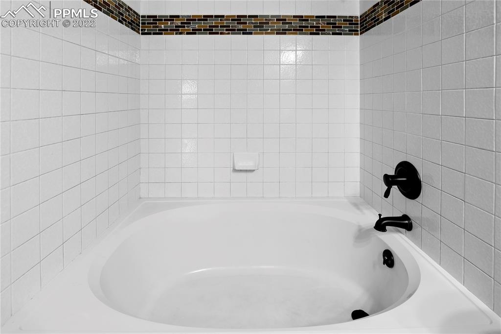 6910 Los Reyes Circle Colorado Springs, CO 80918 - Photo 13 of 38 a white bath tub sitting in a bathroom and shower