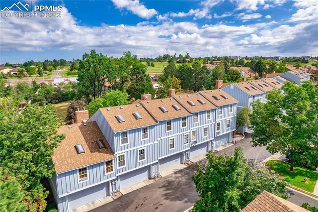 an aerial view of a house with a yard and mountain view in back