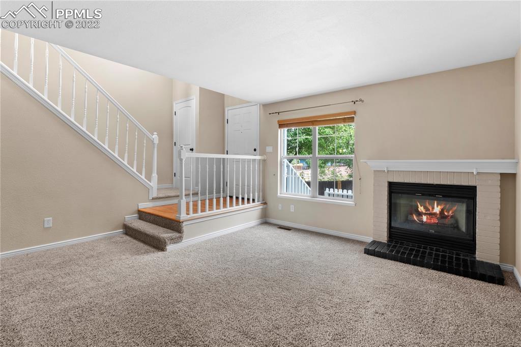 6910 Los Reyes Circle Colorado Springs, CO 80918 - Photo 4 of 38 a view of an empty room with fireplace and a window
