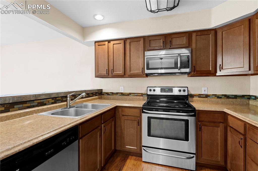 6910 Los Reyes Circle Colorado Springs, CO 80918 - Photo 6 of 38 a kitchen with a sink stove and microwave