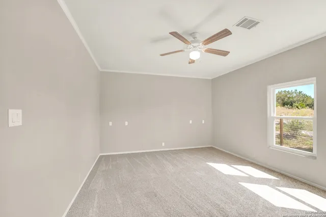 an empty room with a window and a fan