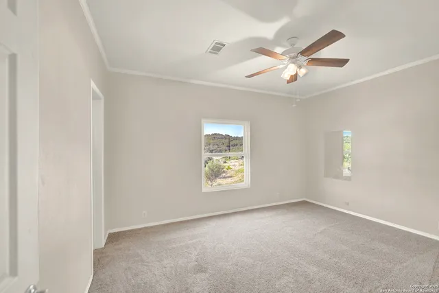 an empty room with windows and fan