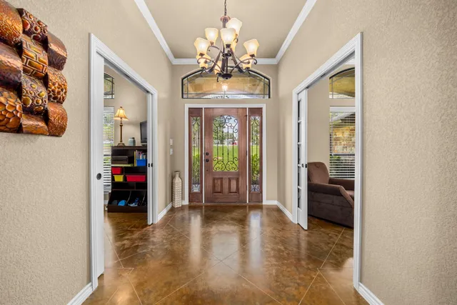 a view of a livingroom with a chandelier furniture and windows