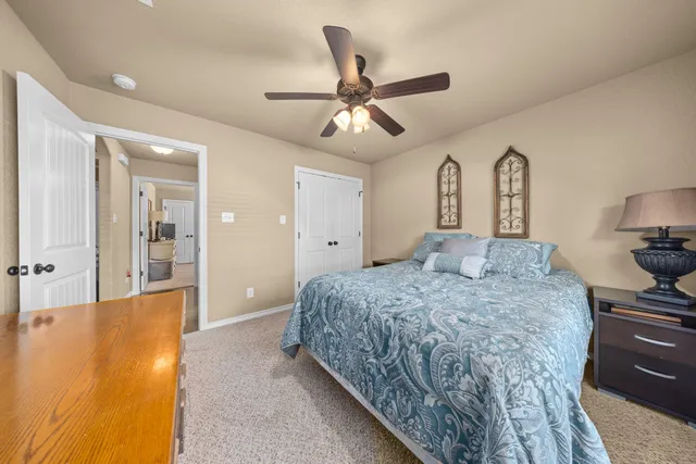 a spacious bedroom with a bed and ceiling fan