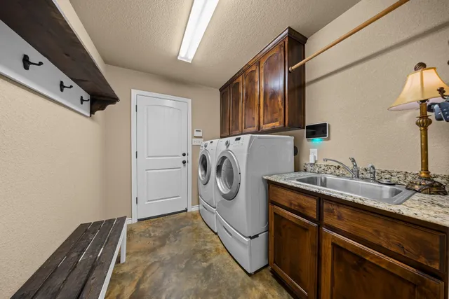 a utility room with sink dryer and washer