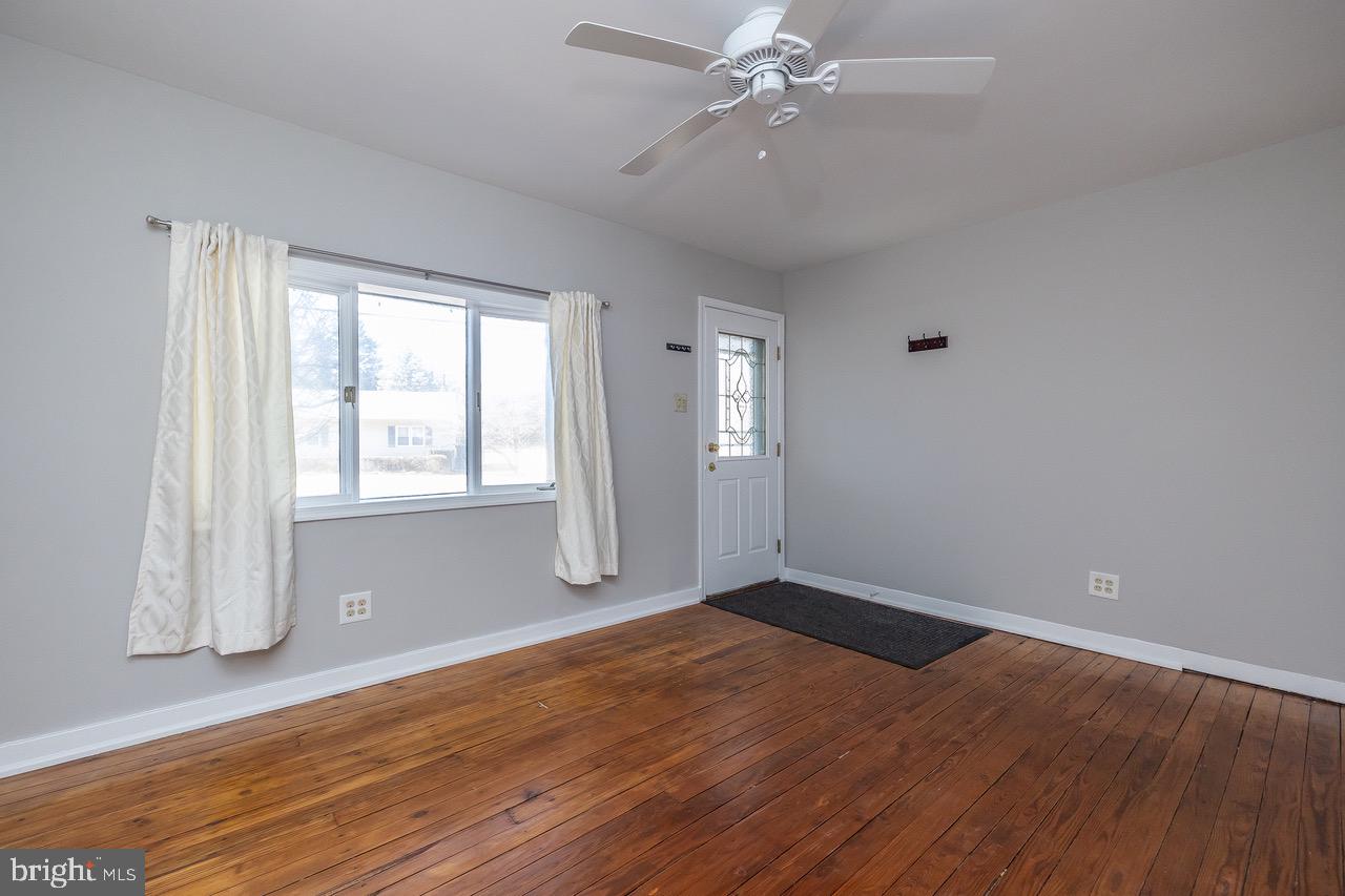 242 Sunset Road Runnemede, NJ 08007 - Photo 8 of 27 an empty room with wooden floor fan and windows