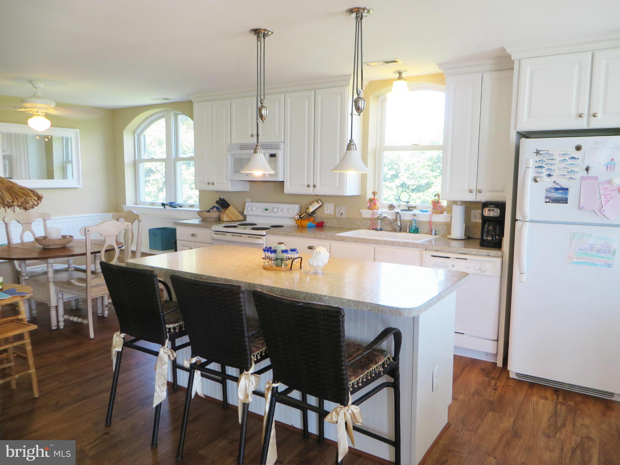 16144 Murray Road Ridge, MD 20680 - Photo 5 of 30 a kitchen with stainless steel appliances granite countertop a white center island a stove a table and chairs