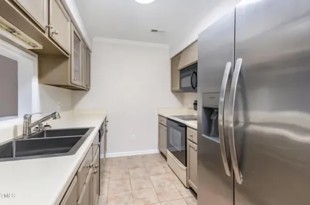 a kitchen that has a sink stainless steel appliances and cabinets
