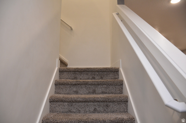 1842 South 1280th Street West Logan, UT 84321 - Photo 9 of 21 Carpeted staircase featuring a painted handrail and white baseboards