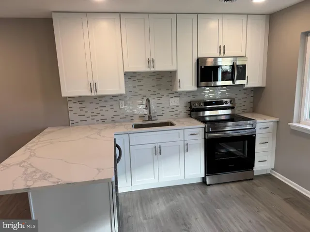 a kitchen with stainless steel appliances a stove a sink and a microwave