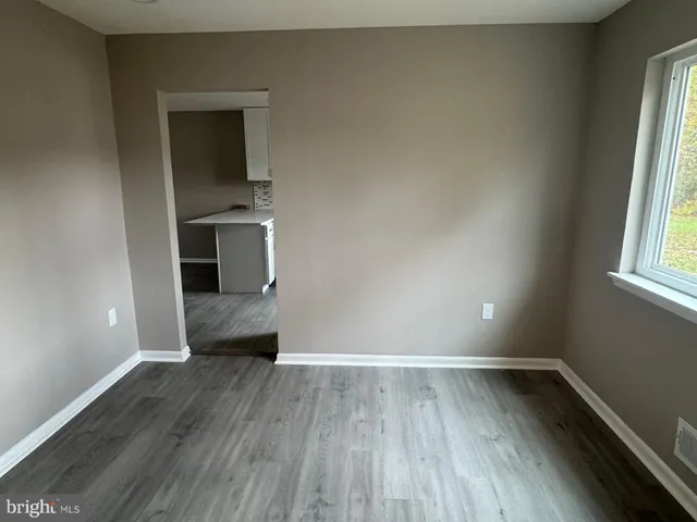a view of a room with wooden floor and a window