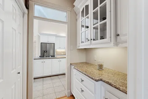 a kitchen with granite countertop white cabinets and stainless steel appliances