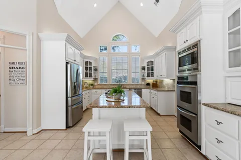 a kitchen with stainless steel appliances granite countertop a refrigerator and a stove top oven
