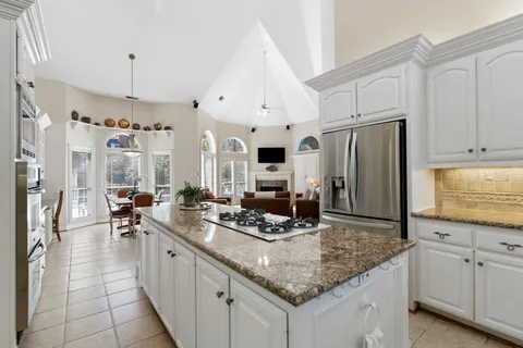 a kitchen with stainless steel appliances granite countertop a stove refrigerator and cabinets
