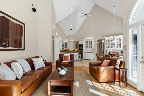 a living room with furniture kitchen view and a large window