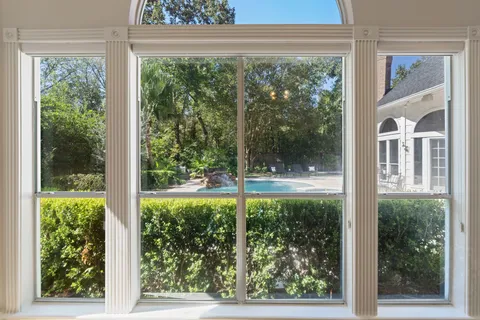 a view of a room with a large window and wooden floor