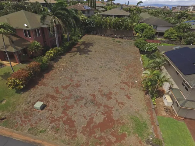 an aerial view of a house with a yard and trees all around
