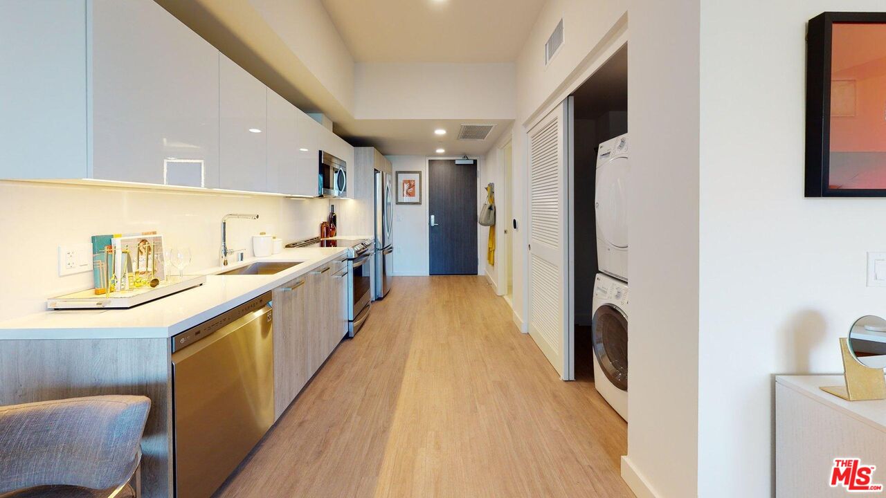 2801 Sunset Place, Unit 2213 Los Angeles, CA 90005 - Photo 4 of 7 a kitchen with stainless steel appliances a refrigerator a sink a stove and white cabinets