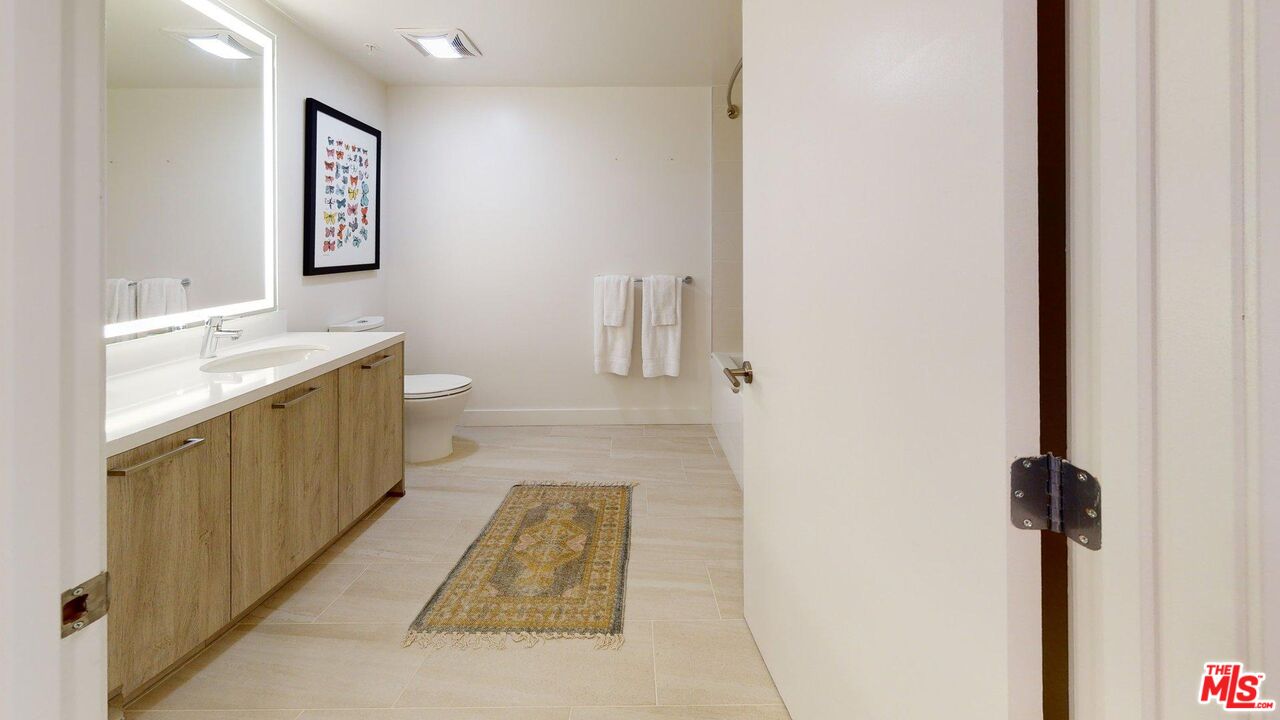 2801 Sunset Place, Unit 2213 Los Angeles, CA 90005 - Photo 6 of 7 a bathroom with a sink a toilet and mirror