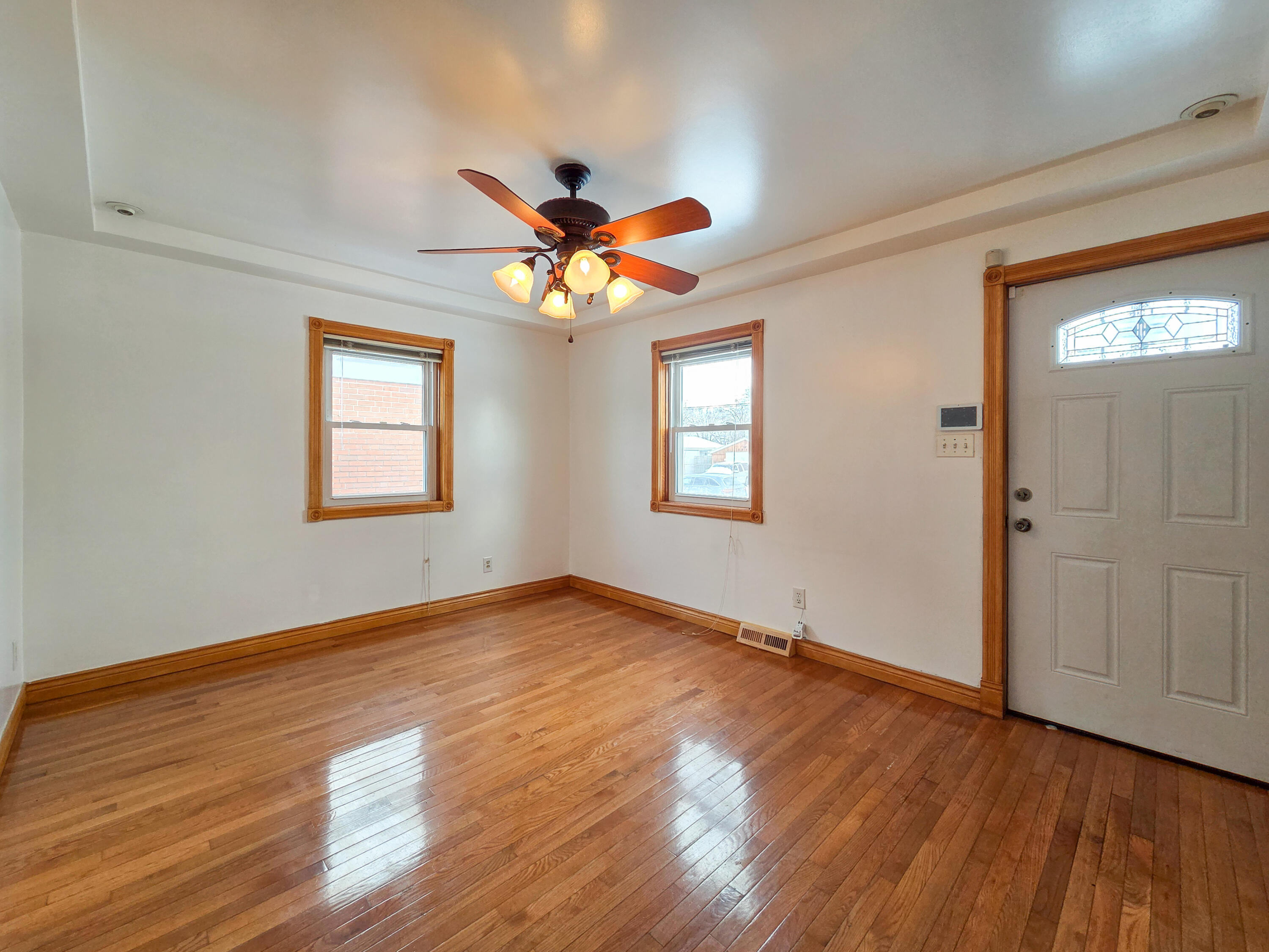 1472 Atlas Street Hammond, IN 46320 - Photo 2 of 27 an empty room with wooden floor chandelier fan and windows