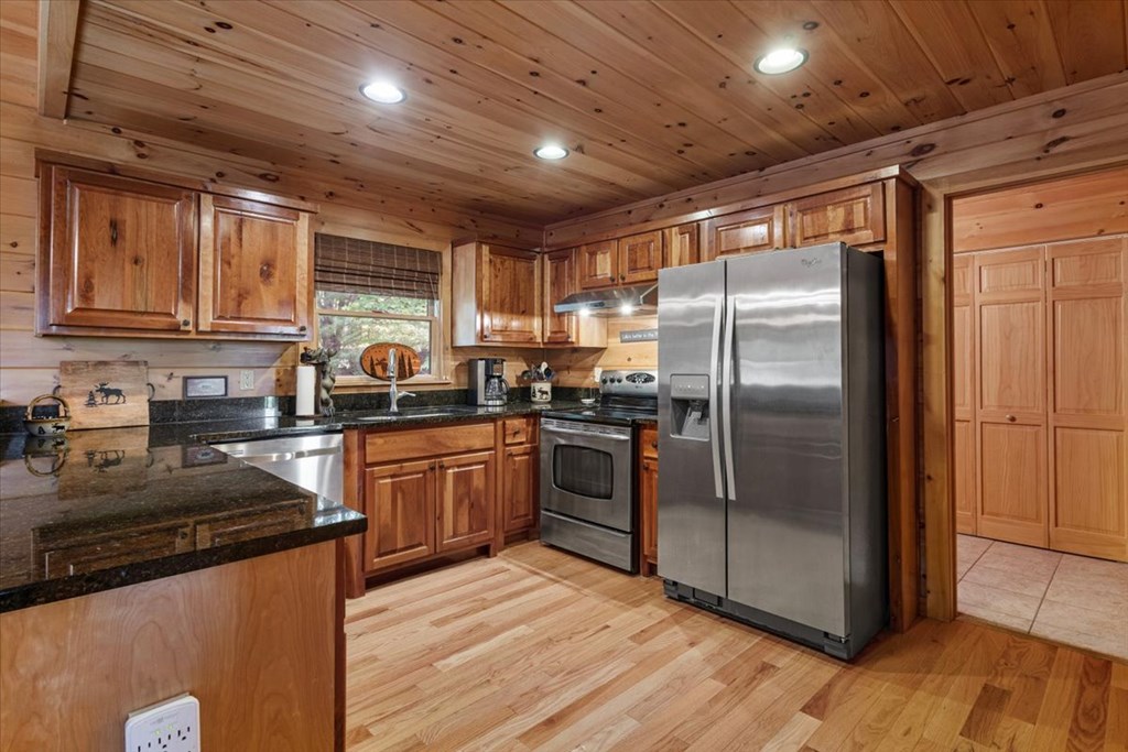 244 Indian Ridge Road Epworth, GA 30541 - Photo 22 of 47 a kitchen with granite countertop a refrigerator and wooden cabinets