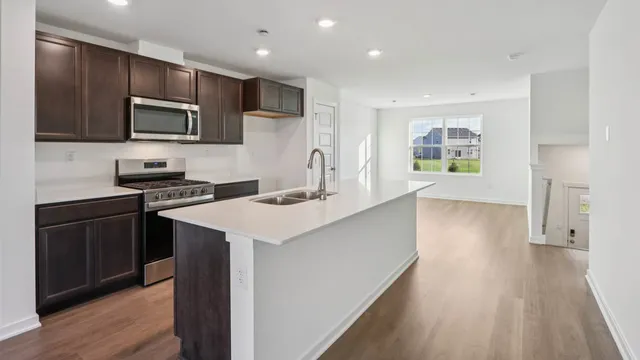 a view of a kitchen with wooden floor and electronic appliances