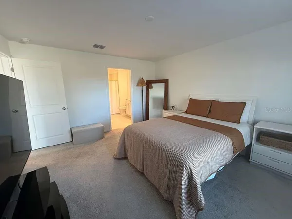 a bedroom with a bed and a flat tv screen