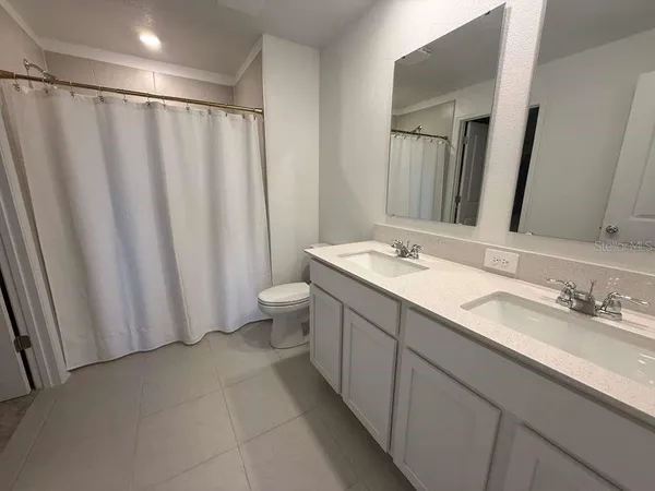 a bathroom with a double vanity sink and a mirror