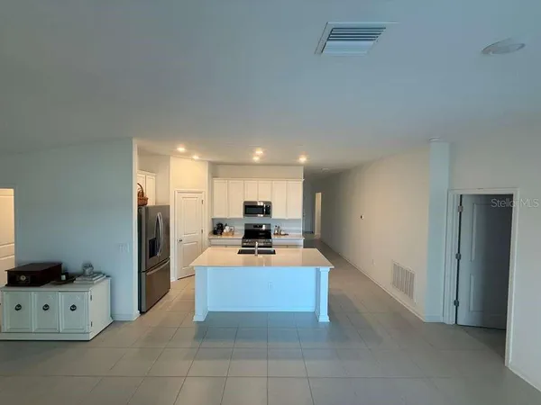 a large white kitchen with cabinets