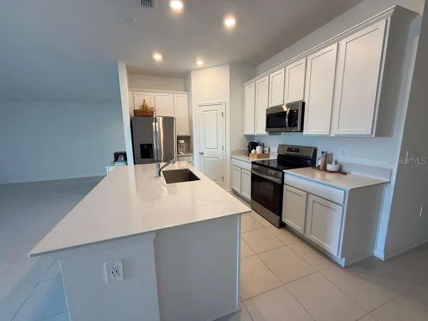 a kitchen with a sink a counter top space cabinets and stainless steel appliances