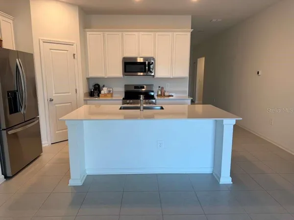 a kitchen with stainless steel appliances a refrigerator sink stove and microwave