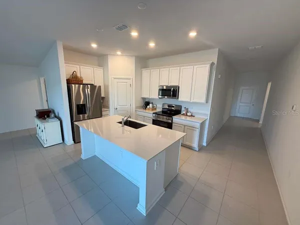 a kitchen that has a lot of cabinets in it and appliances