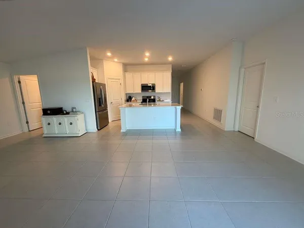 a view of kitchen with furniture and refrigerator